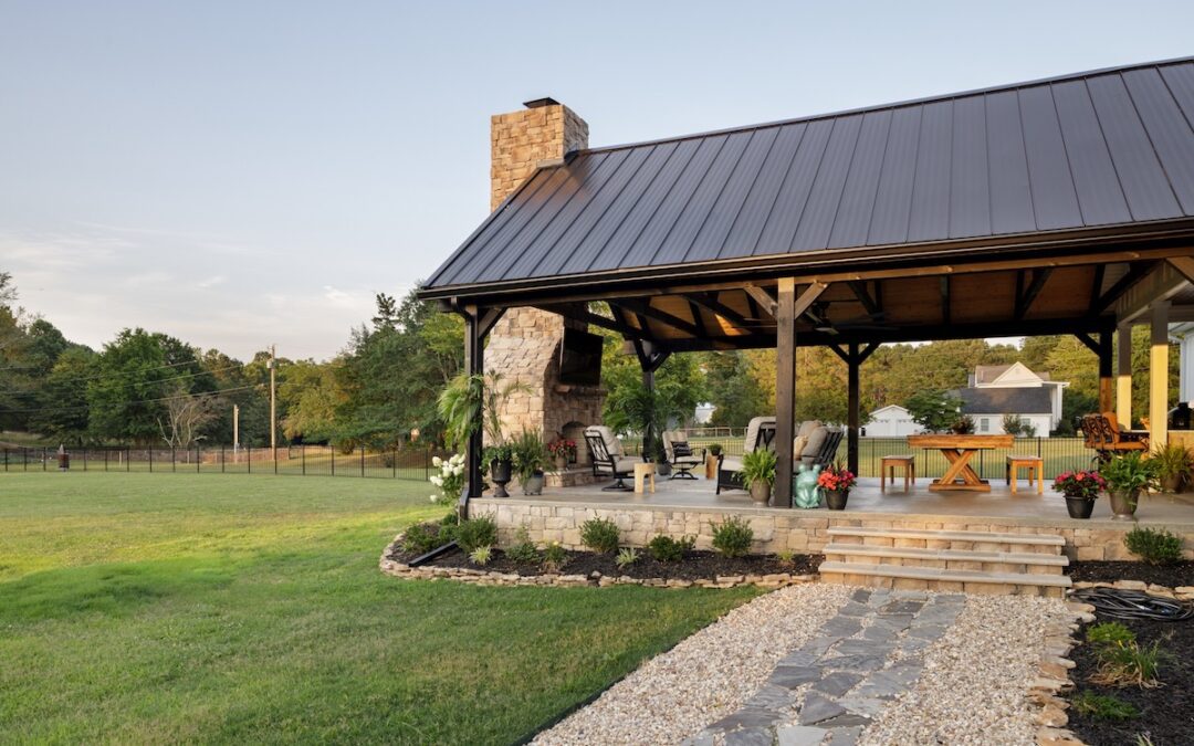 photo of outdoor living space with metal roof and large stone fireplace